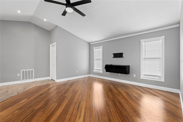 unfurnished living room featuring baseboards, visible vents, vaulted ceiling, and hardwood / wood-style floors