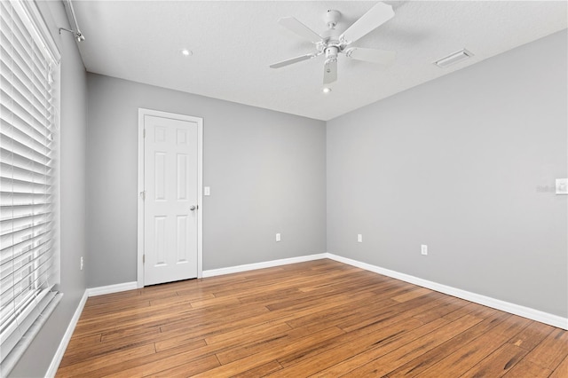 unfurnished room featuring light wood-type flooring, baseboards, visible vents, and ceiling fan