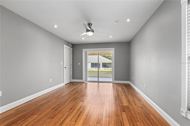 spare room with recessed lighting, wood-type flooring, a ceiling fan, and baseboards