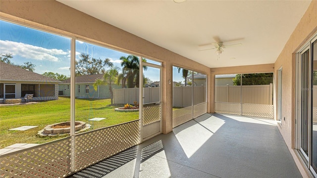 unfurnished sunroom featuring ceiling fan