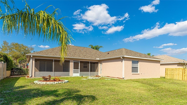 rear view of house featuring a yard, a fenced backyard, a sunroom, and stucco siding