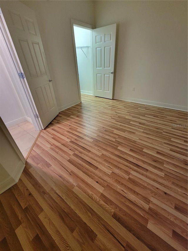 unfurnished bedroom with baseboards and light wood finished floors