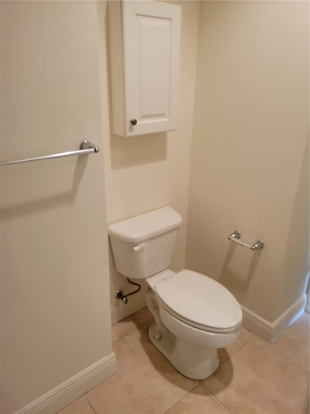 bathroom featuring toilet, tile patterned flooring, and baseboards