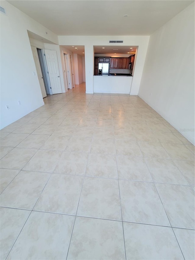 unfurnished living room featuring light tile patterned floors and visible vents