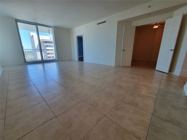 empty room with visible vents, ceiling fan, baseboards, and light tile patterned floors