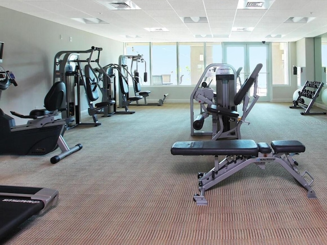 workout area featuring a paneled ceiling, visible vents, and baseboards