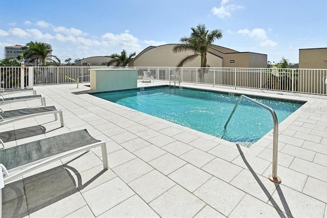 community pool with a patio and fence