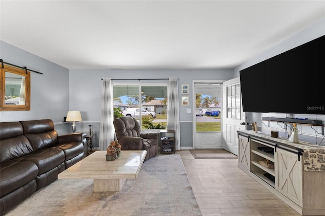 living area with light wood-type flooring and a barn door