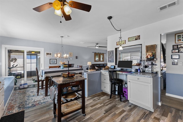 kitchen featuring white cabinetry, decorative light fixtures, dark wood-style floors, and visible vents