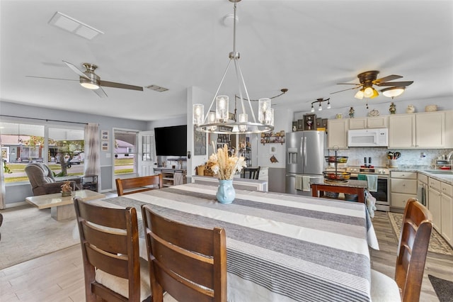 dining space with ceiling fan, visible vents, and light wood-style flooring