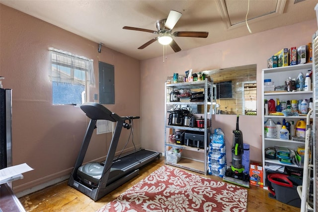 workout area with electric panel, baseboards, attic access, and ceiling fan