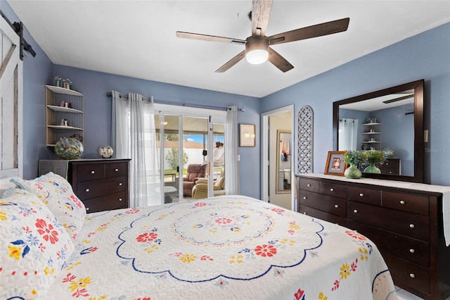 bedroom with a barn door, ceiling fan, and access to outside