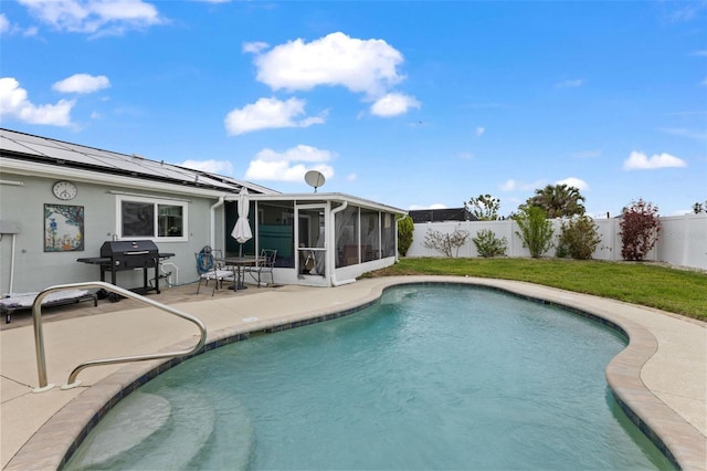 rear view of property featuring a fenced in pool, a lawn, a fenced backyard, a sunroom, and a patio area