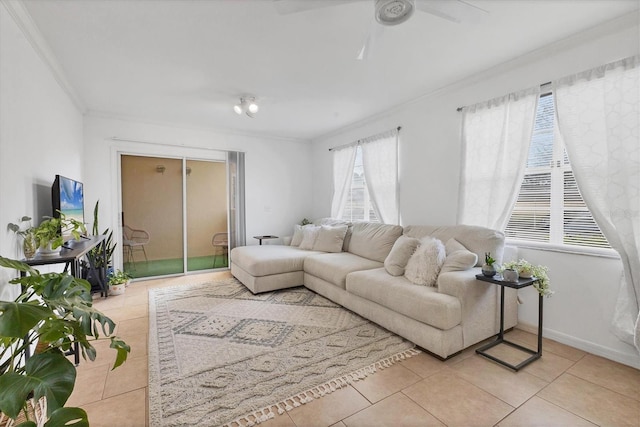 living area with light tile patterned floors, ceiling fan, baseboards, and crown molding