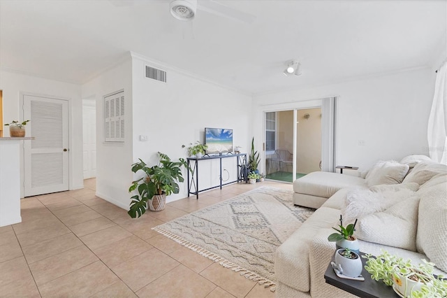 living area with tile patterned flooring, visible vents, crown molding, and baseboards