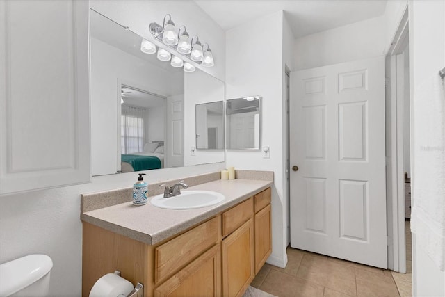 bathroom featuring toilet, tile patterned flooring, vanity, and ensuite bathroom