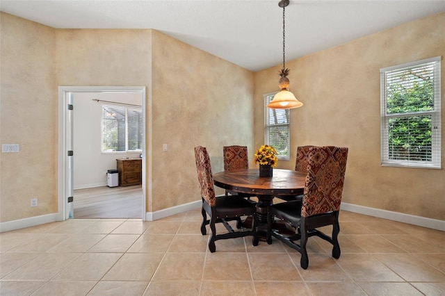 dining area featuring a healthy amount of sunlight, light tile patterned floors, and baseboards