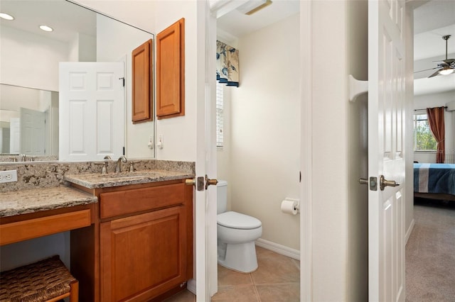 ensuite bathroom with baseboards, toilet, tile patterned floors, ensuite bathroom, and vanity