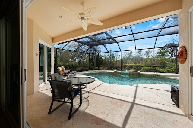 view of swimming pool with ceiling fan, a patio, a pool with connected hot tub, and glass enclosure