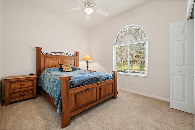 bedroom featuring a ceiling fan, light carpet, vaulted ceiling, and baseboards