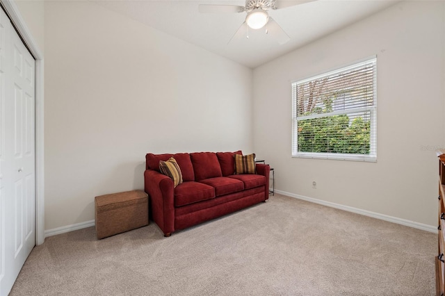 sitting room featuring a ceiling fan, light carpet, and baseboards