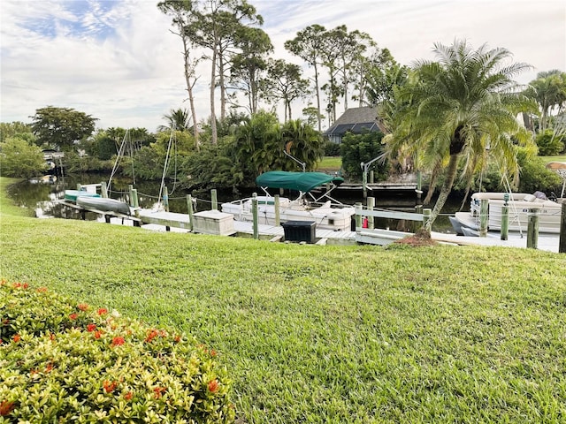 surrounding community featuring a lawn and a boat dock