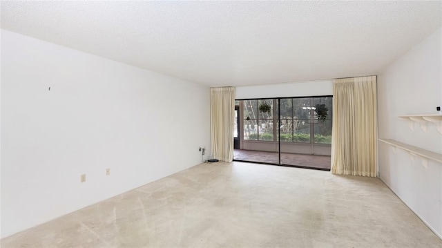 carpeted spare room featuring a textured ceiling