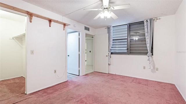 unfurnished room with a textured ceiling, carpet, and visible vents