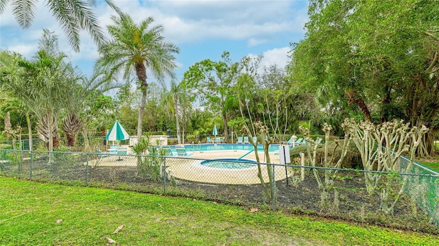 pool featuring a lawn and fence