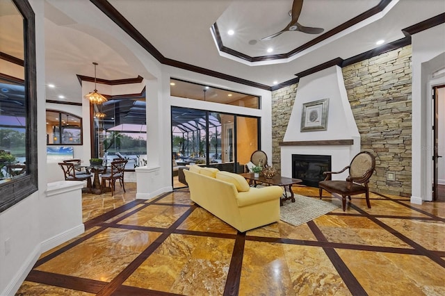 living area featuring baseboards, recessed lighting, ornamental molding, a glass covered fireplace, and marble finish floor