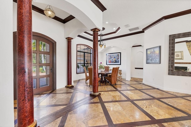 foyer entrance with marble finish floor, baseboards, ornate columns, and arched walkways