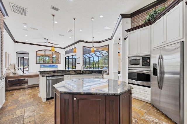 kitchen with stone tile floors, visible vents, appliances with stainless steel finishes, and a sink