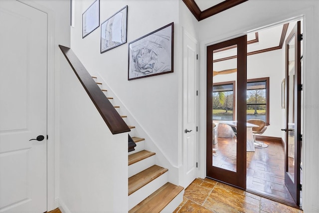 foyer entrance featuring french doors, stone tile flooring, stairs, and crown molding