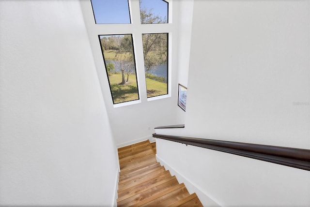 staircase featuring baseboards and wood finished floors