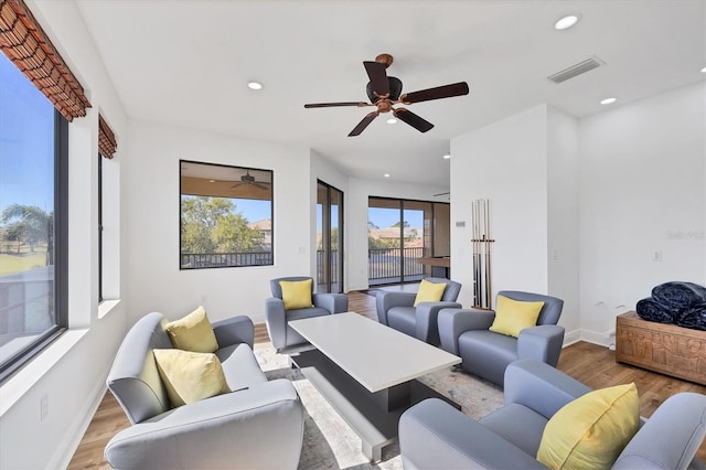 living area featuring visible vents, recessed lighting, baseboards, and wood finished floors