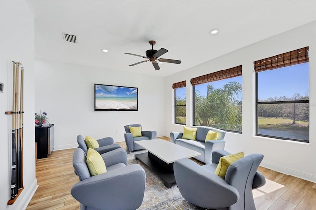 living room featuring light wood-type flooring, visible vents, baseboards, and recessed lighting