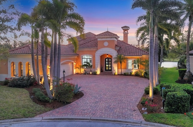 7327 Greystone St, Lakewood Ranch, FL 34202 - mediterranean / spanish-style house with stucco siding, decorative driveway, a garage, a tile roof, and french doors