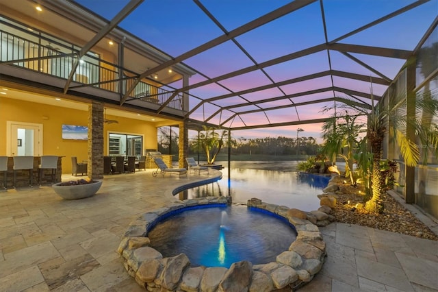 7327 Greystone St, Lakewood Ranch, FL 34202 - pool at dusk featuring a pool with connected hot tub, an outdoor bar, glass enclosure, and a patio area