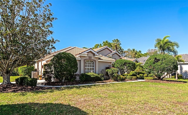 view of front of house with stucco siding, a tiled roof, and a front lawn