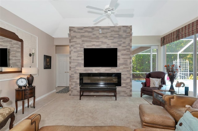 living area featuring baseboards, a healthy amount of sunlight, a ceiling fan, and a tile fireplace