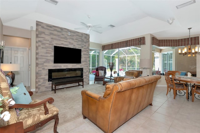 living area with light tile patterned floors, visible vents, ceiling fan with notable chandelier, and a tile fireplace