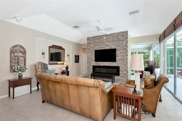 living room with visible vents, a tiled fireplace, a ceiling fan, baseboards, and vaulted ceiling