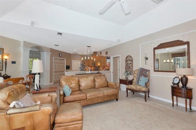 living area featuring visible vents, baseboards, decorative columns, arched walkways, and a ceiling fan