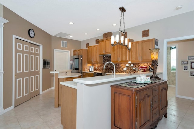 kitchen with visible vents, a kitchen island, decorative backsplash, appliances with stainless steel finishes, and a sink