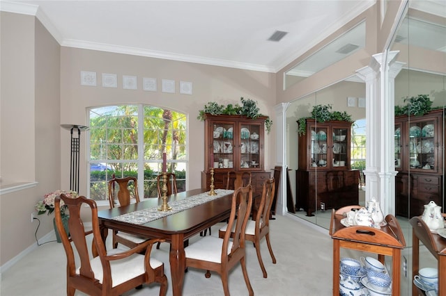 dining room with decorative columns, light colored carpet, visible vents, and crown molding