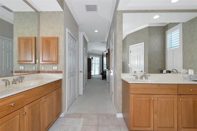 full bathroom featuring crown molding, two vanities, visible vents, and a sink