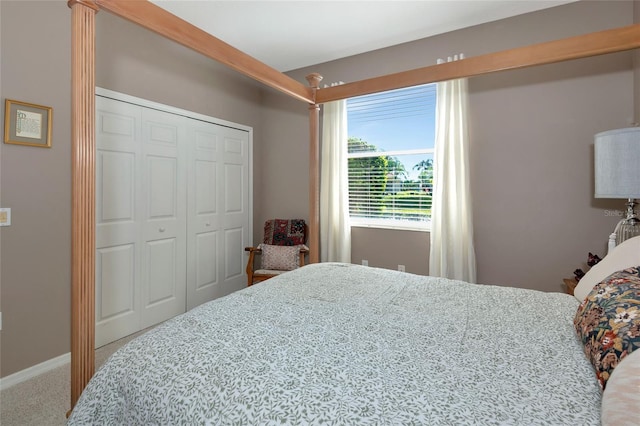 carpeted bedroom featuring a closet and baseboards