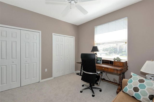 office space with carpet flooring, a ceiling fan, and baseboards