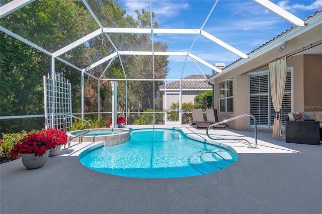 view of swimming pool featuring glass enclosure, a patio, and a pool with connected hot tub