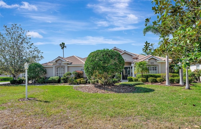 view of front of house featuring a front lawn, a tile roof, and stucco siding